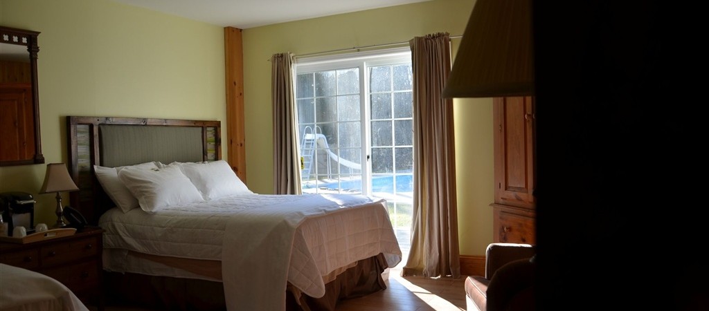 Large ground floor family sized room with two double beds, heated bathroom floor and walkout to poolside patio