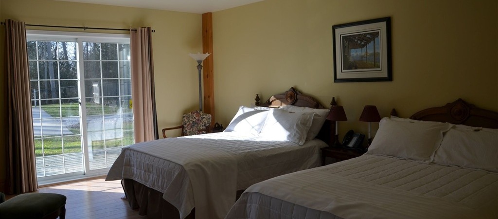 Large ground floor family sized room with two double beds, heated bathroom floor and walkout to poolside patio